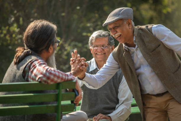 istock Happy senior friends holding hands in park 1911455680