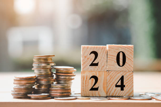 istock Coins stack and wooden blocks number 2024 on blur background. 1911515041