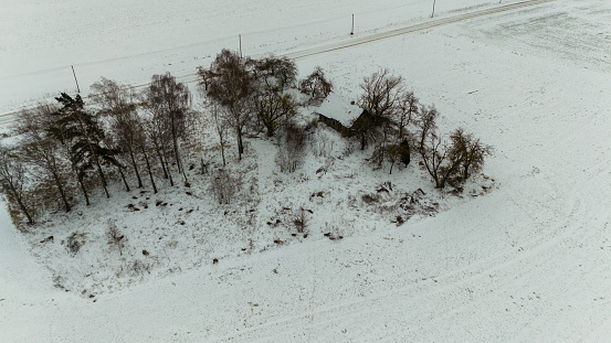 Drone photography of old abandoned wooden house in a rural landscape during winter cloudy day