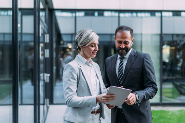 istock Business people using digital tablet outdoors. 1911521740