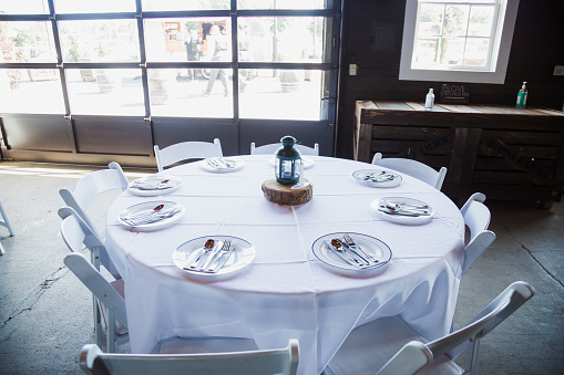 Deserted cafe tables, neatly arranged on a charming veranda, await the buzz of customers.