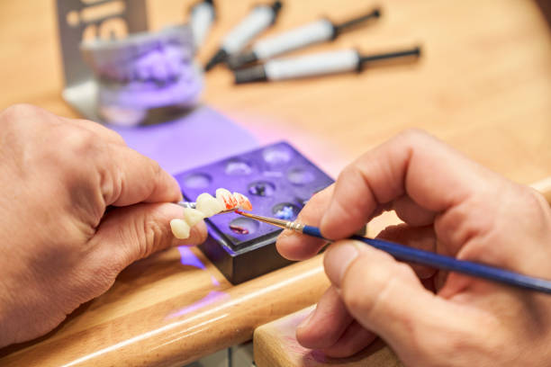 istock Faceless dental technician painting prosthesis 1911524477