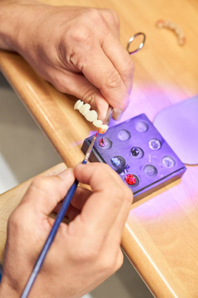 istock Anonymous dental technician painting denture 1911524553