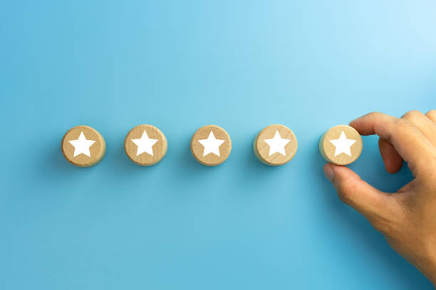 istock Customer experience, satisfaction survey, Evaluation, Increase rating and best excellent services rating concepts. The client's hand picked the five star symbol on wooden cubes on blue background. 1911526207
