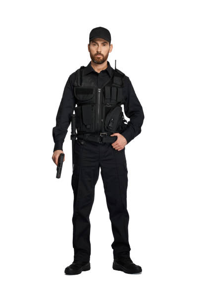 istock Confident police officer in uniform posing with weapon in studio. 1911536603