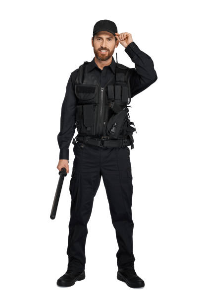 istock Handsome cop wearing peaked cap, while standing with truncheon. 1911539675