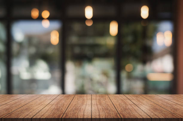 istock Empty wooden table top with lights bokeh on blur restaurant background 1911575742