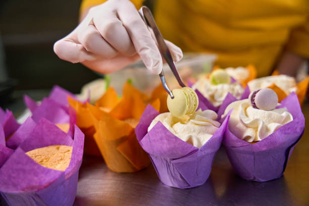 istock Professional baker busy with decorating dessert on kitchen countertop 1911584187