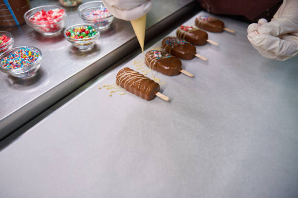 istock Confectioner busy with decorating of cake popsicles on kitchen countertop 1911584212