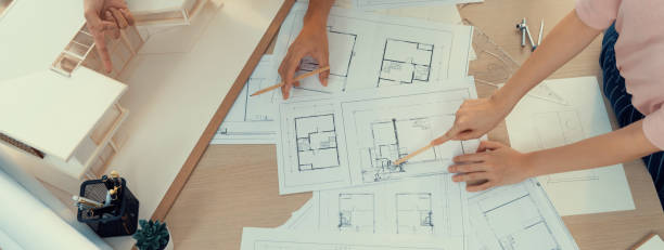 istock Skilled engineer team meeting presents house construction. Top view. Burgeoning. 1911595355