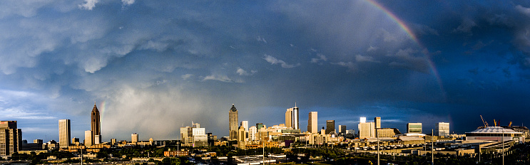 Drone show of City of Atlanta, GA, at sunset with severe thunderstorm clouds passing over and a rainbow.