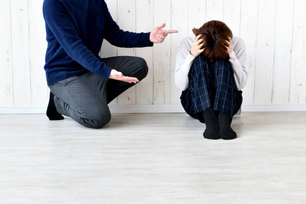 istock Man talking to woman holding head 1911602060