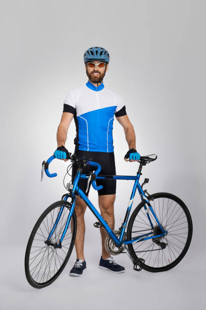 istock Happy cyclist in cycle kit standing with bike in studio. 1911602066