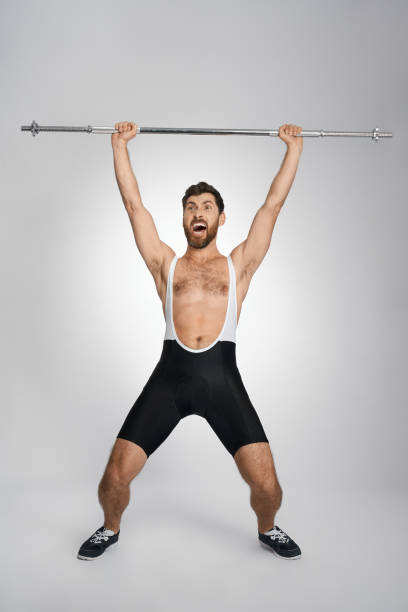 istock Happy powerlifter screaming, while lifting unweighted barbell. 1911602284