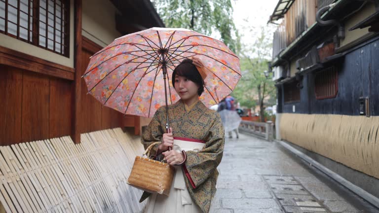 Young woman in Kimono / Hakama walking in traditional Japanese town in Kyoto