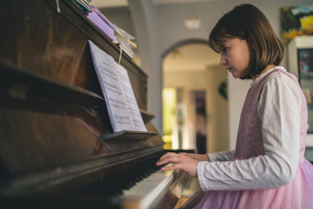 istock Girl playing grand piano 1911611236