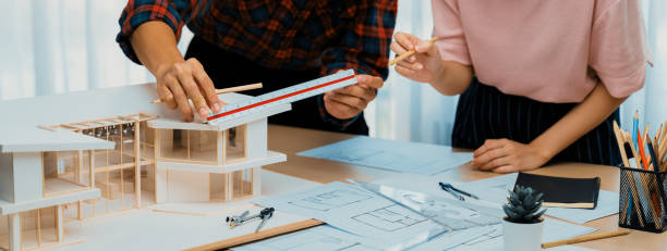istock Smart architect engineer working together and measuring house model. Burgeoning. 1911611239