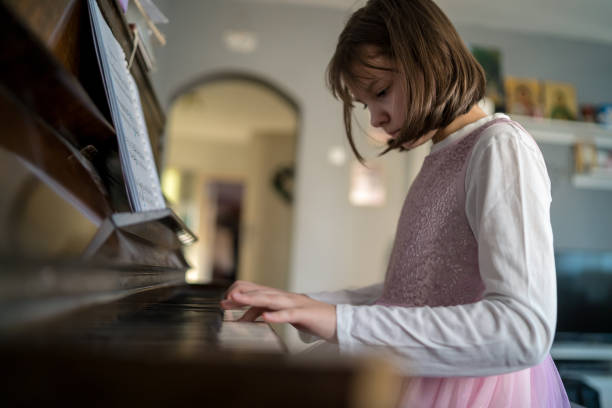 istock Girl playing grand piano 1911611755