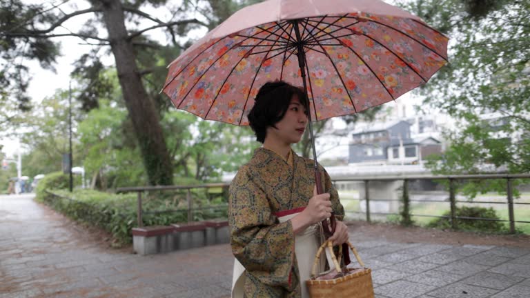 Young woman in Kimono / Hakama walking by the river