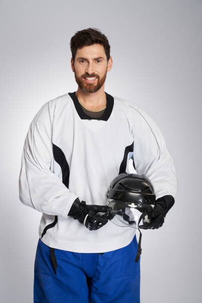 Young Caucasian male Pro Hockey goalie at the training at the hockey arena. Portrait of the player on the ice.