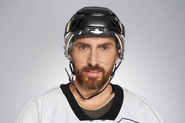 istock Handsome bearded hockey player in black helmet. 1911623821