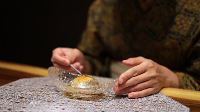 Young woman in Kimono / Hakama eating jelly for dessert in Japanese restaurant