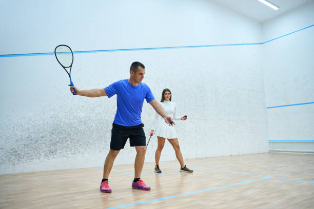 istock Man coach working with woman focuses on skill development during squash lesson 1911636946