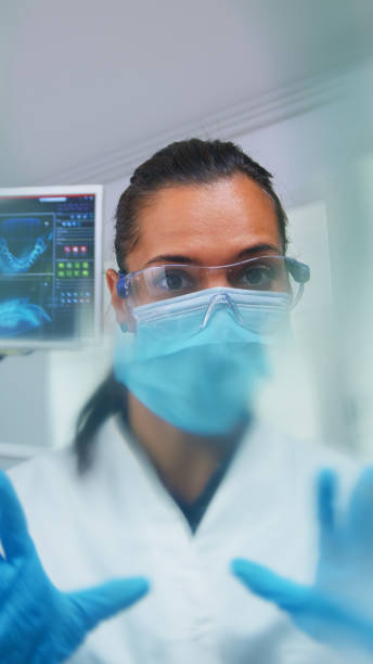 istock Dentist leaning over patient putting oxigen mask, patient pov 1911648638