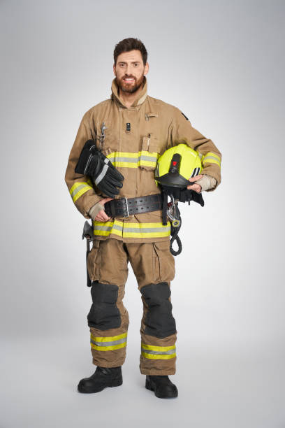 istock Strong bearded firefighter smiling to camera indoors. 1911680041