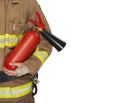 Unrecognizable male firefighter in uniform holding red extinguisher. Crop view of man in fireman workwear carrying fire extinguisher, isolated on white background, copy space. Concept of safety, work.