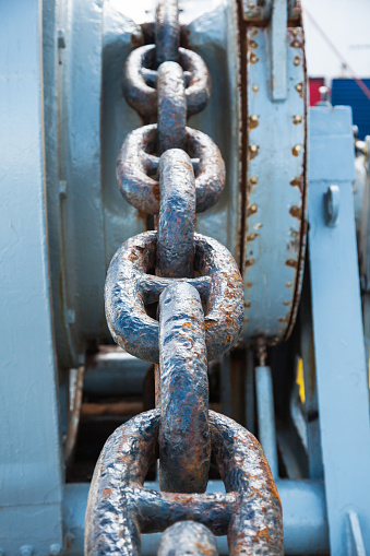 Rusty anchor chain on a winch on a ship.
