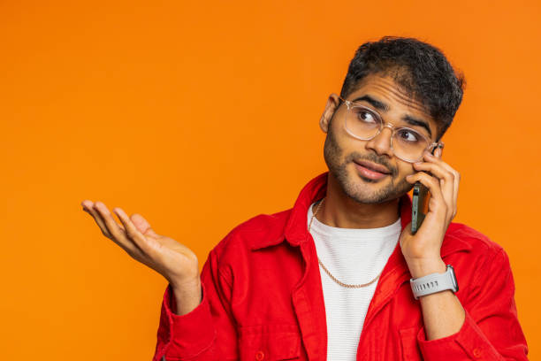 disinterested tired indian man having annoyed boring talk on smartphone online conversation, quarrel - rudeness blah customer boredom - fotografias e filmes do acervo