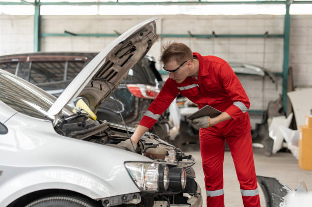 istock Mechanic man in red uniform using tablet checking car engine at auto car garage service. Car repair and maintenance concept. 1911759216