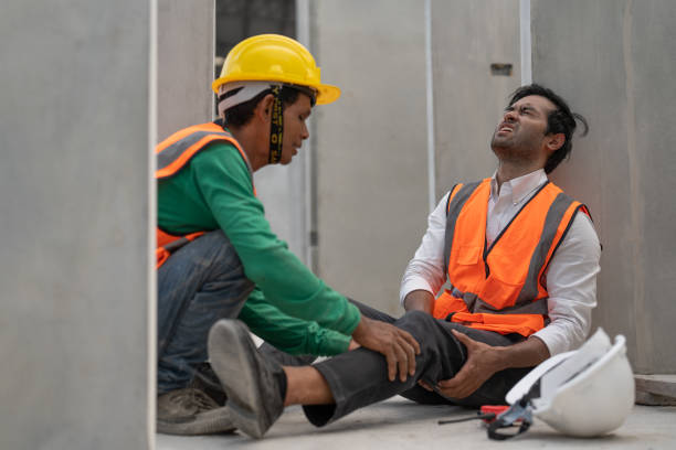 istock Asian man engineer feeling pain in his leg from accident while working in factory making precast concrete wall for real estate housing. Male worker colleague is helping him. 1911762819