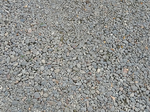 The arrangement of dry pebbles forms an aesthetic background. View from above.