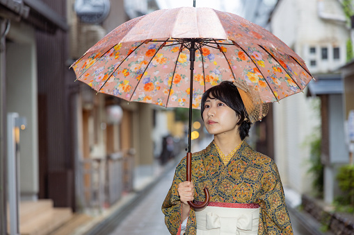 Young female tourist in Kimono / Hakama walking on traditional Japanese town in Kyoto