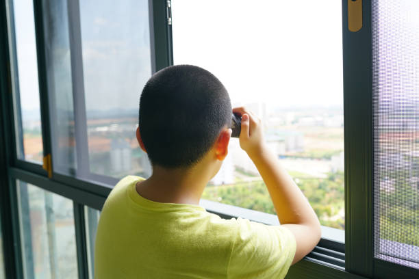 istock kid with telescope watching outdoor near window 1911773328