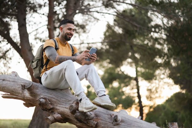 istock Hiker man resting in nature looking at his smart phone 1911802763