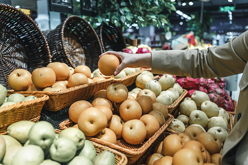 Young Asian women shopping for fresh fruits in supermarkets