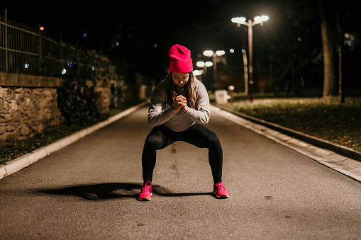 a young woman exercises at night on the street