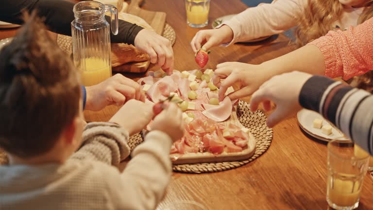 SLO MO High Angle Shot of Crop Family Having Cold Cut Platter at Dining Table at Home