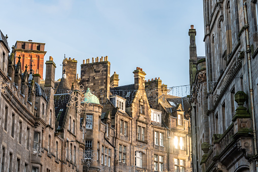 Sun shines on old town Edinburgh, buildings above shops