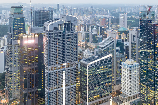 Bottom view of modern skyscrapers in business district against blue sky