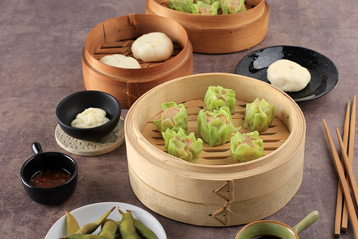 Vegetable Shumai with Green Skin Color, Steamed Dim Sum Dumpling on Bamboo Steamer. Copy Space