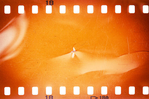Dusty and grungy 35mm film texture or surface. Perforated scratched camera film isolated on white background.