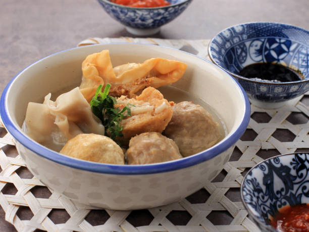 bakso malang, meatball soup with various side dish like tofu fried shiumay, or bakso goreng. served on the table with sambal, soysauce, and tomato sauce. - fine dining grilled spring onion healthy lifestyle imagens e fotografias de stock