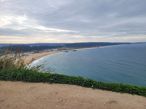 A view of Nazaré and Praia da Nazare on a calm and cloudy day.