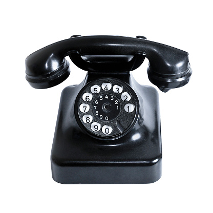 Old black vintage desk phone on white background (built in Germany in the 1940s).