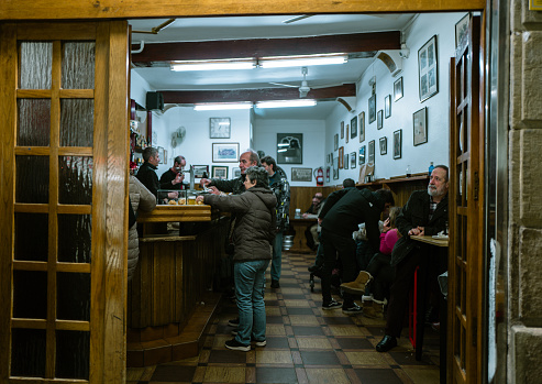 December 29th,2023,San Sebastian,Basque Spain: Locals are ordering and enjoying eating Pinchos at a very authentic local Pinchos Bar. Pincho is also known as Pintxo or Tapas, which is originally born in San Sebastián and became the most popular snack for spanish people before dinner.