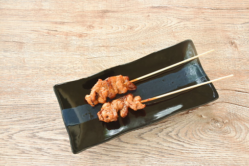 roasted slice chicken dressing Japanese teriyaki sauce stabbing wooden stick on plate